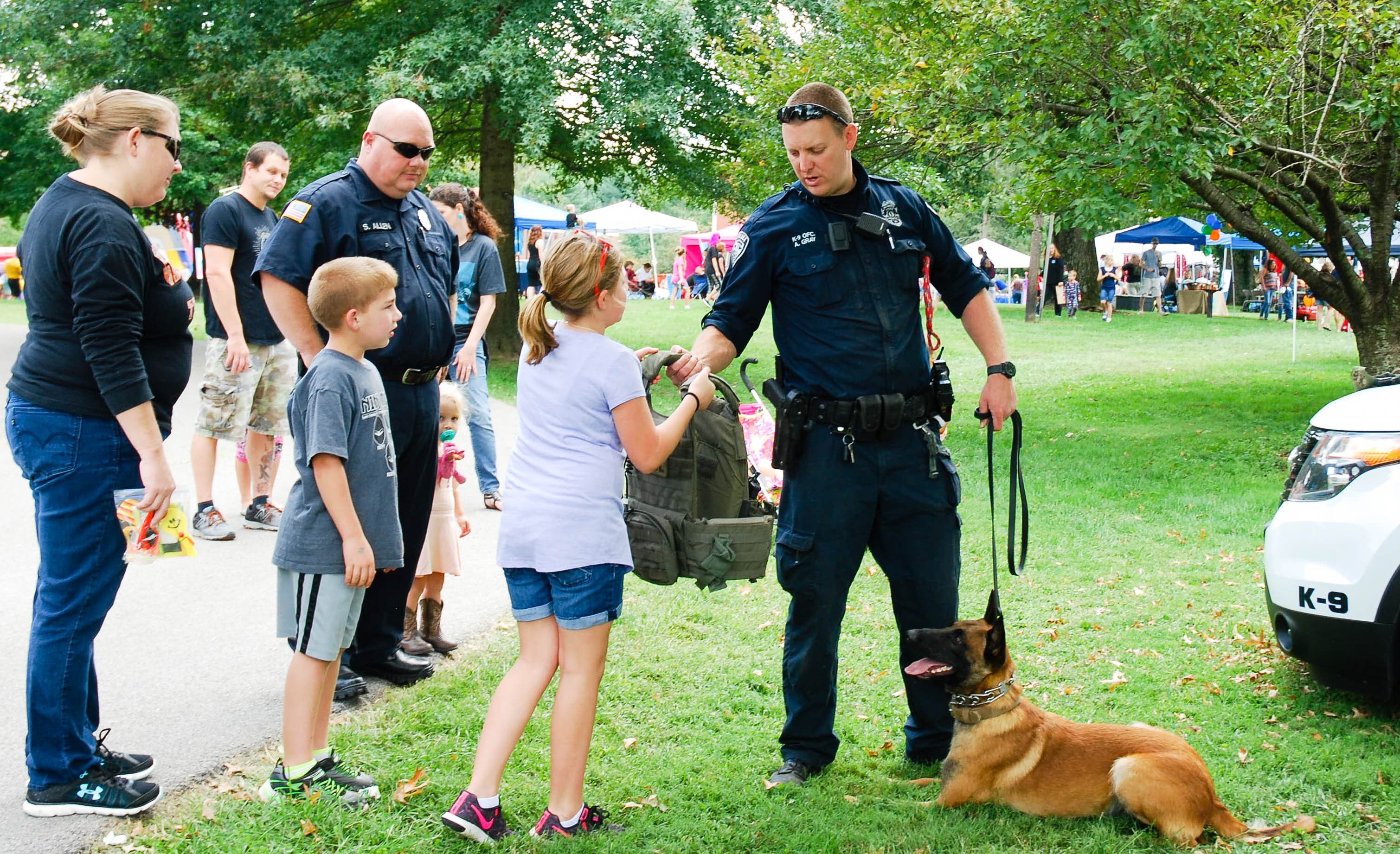 Police officer and dog doing demonstration with family watching 