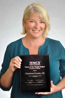 Damema Mann presenting Voice of the People Award to Gunnison County, Colorado