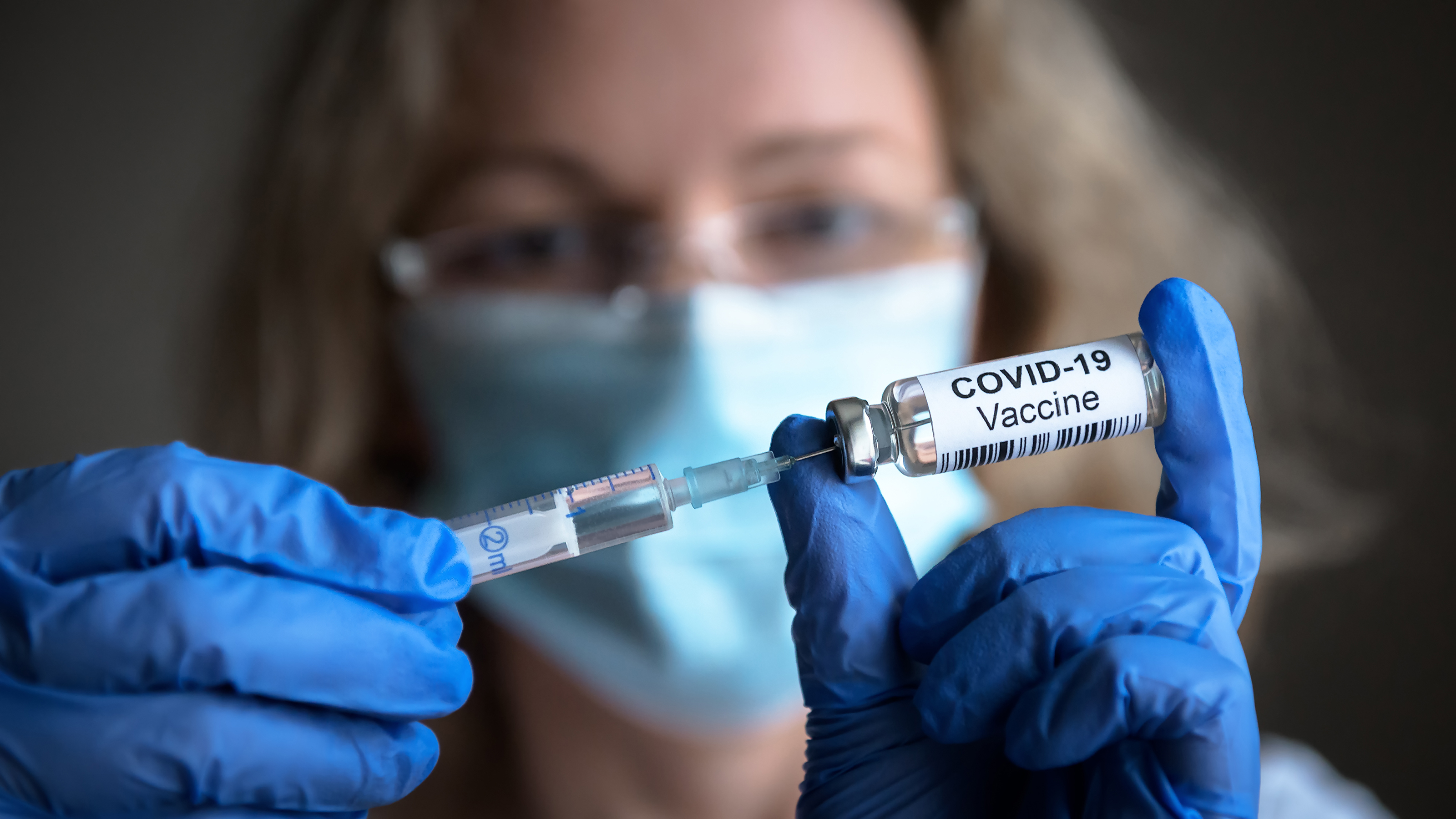 Woman with vial of COVID-19 vaccine.